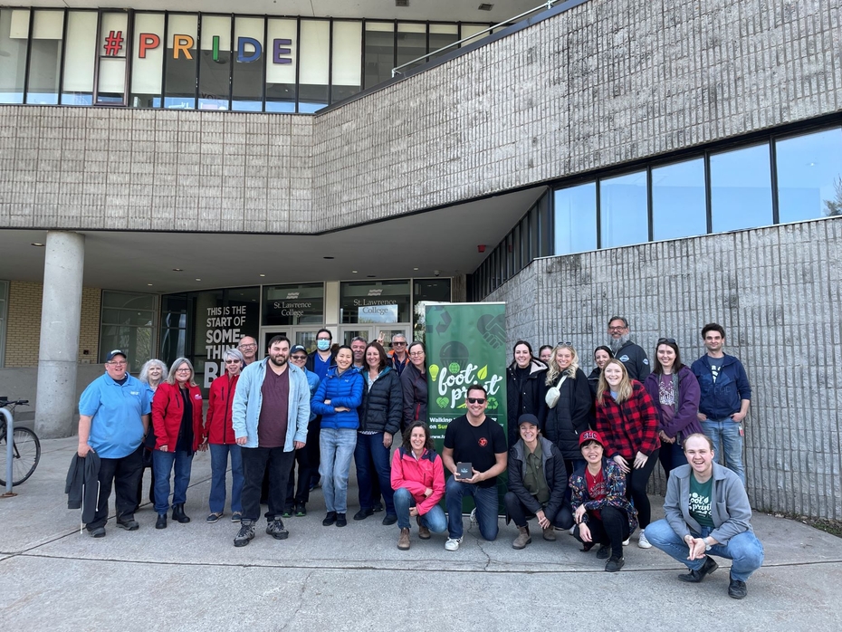 A group of 44 SLC volunteers pose together in front of the campus' main entrance